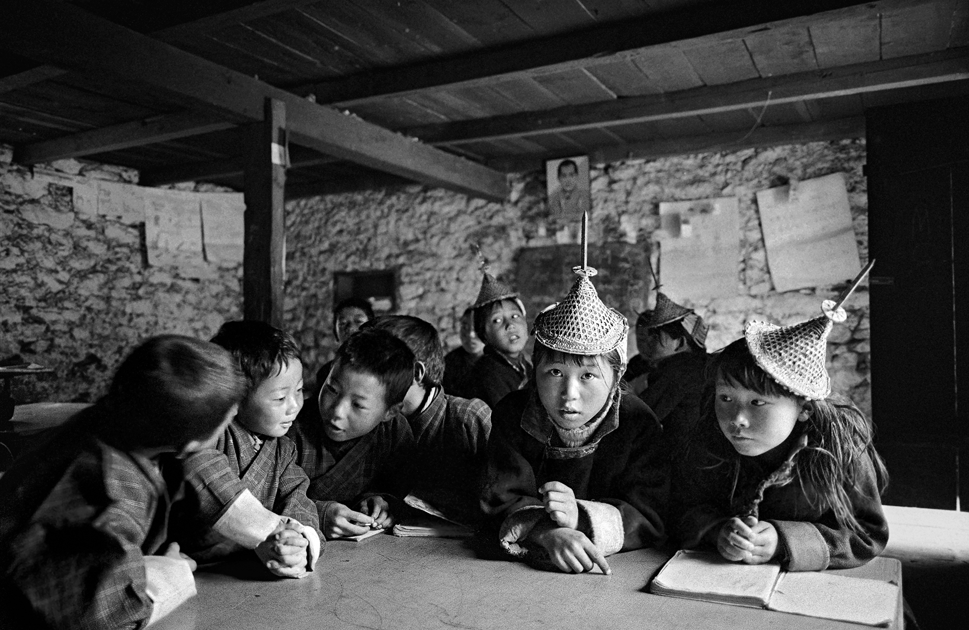 A group of Bhutanese children crowding around a table in a Bhutanese school.