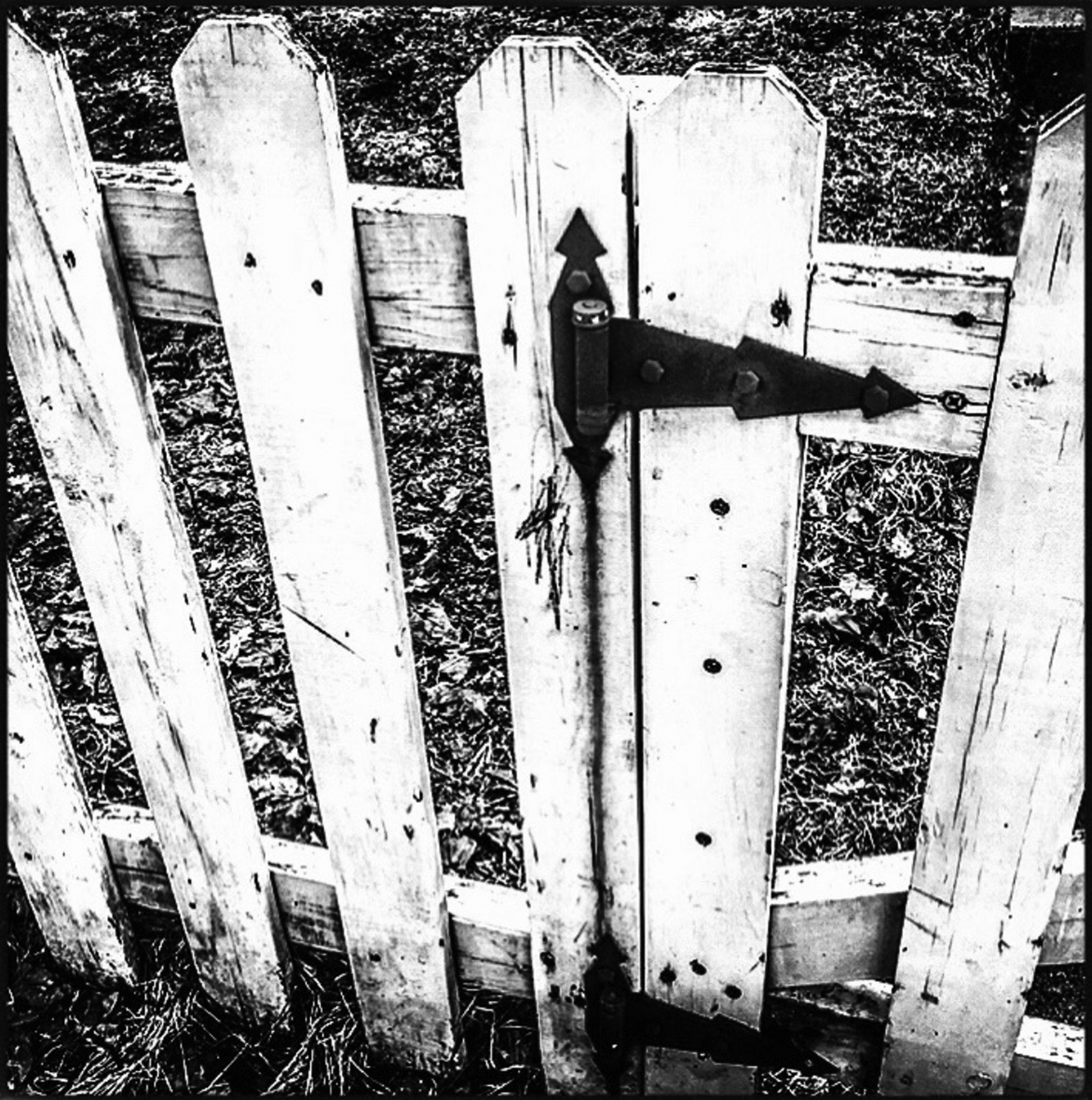 Close-up of a well-worn white picket fence and gate.
