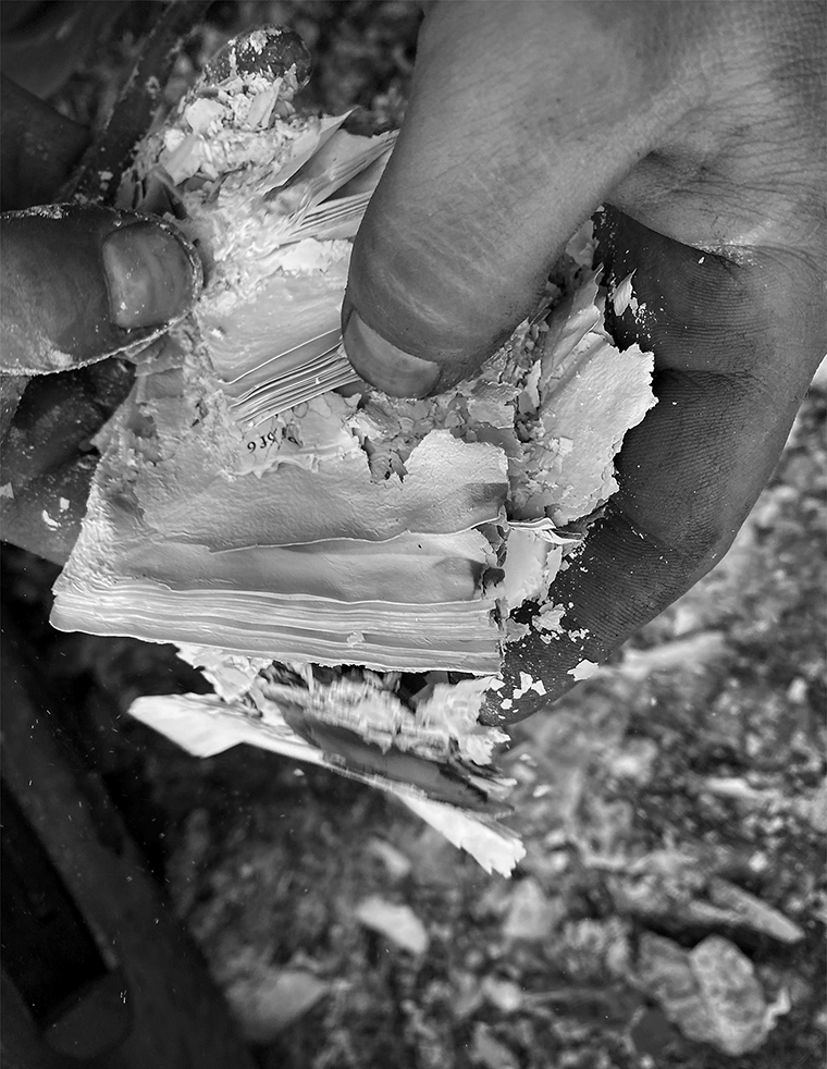 Close-up of hands holding burned sheets of paper.