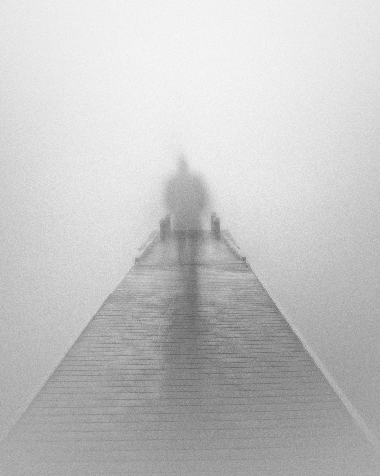 The ghostly silhouette of a person at the end of a pier.