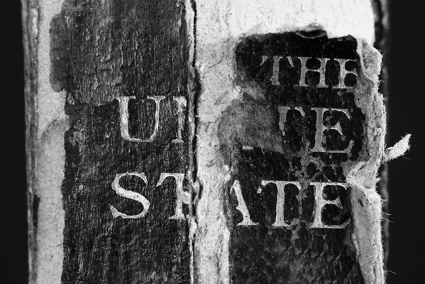A close-up of an old book’s spine. The material is disintegrating, but the words “The United States” are still legible.