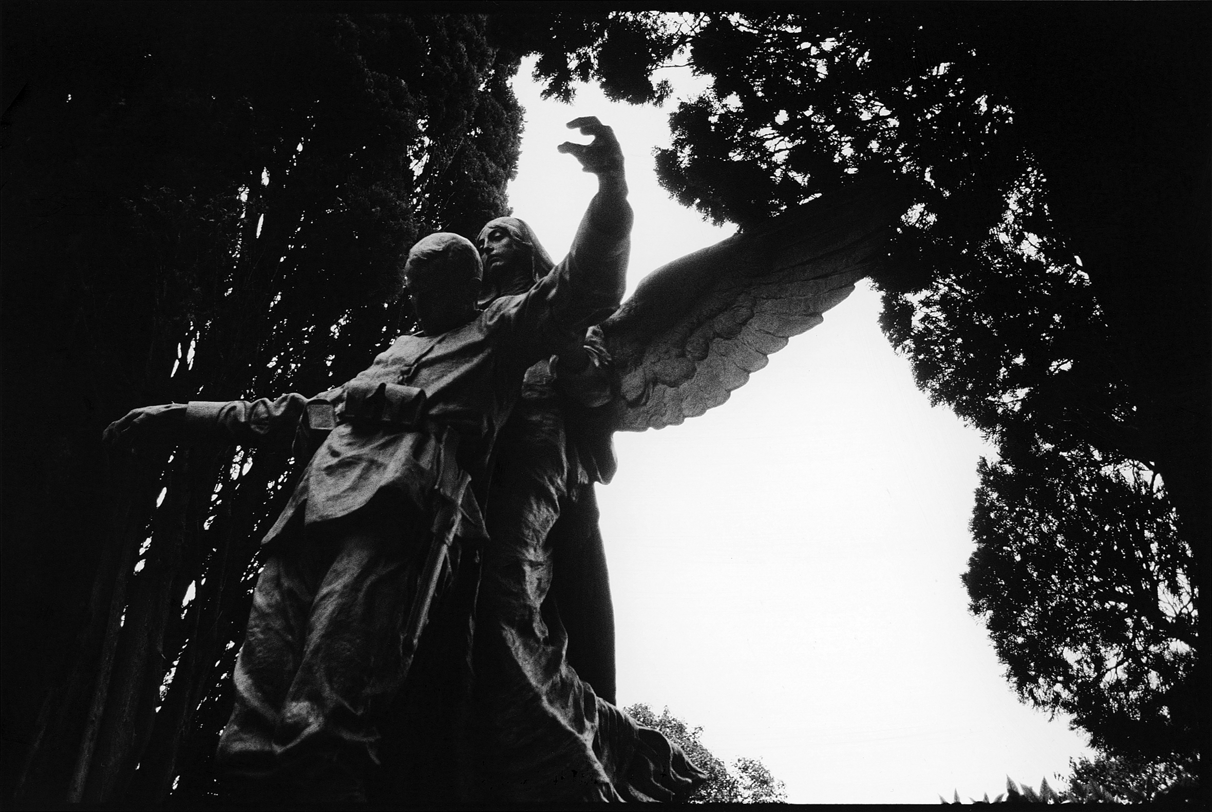 A statue of an angel with outstretched wings carrying a dead soldier.
