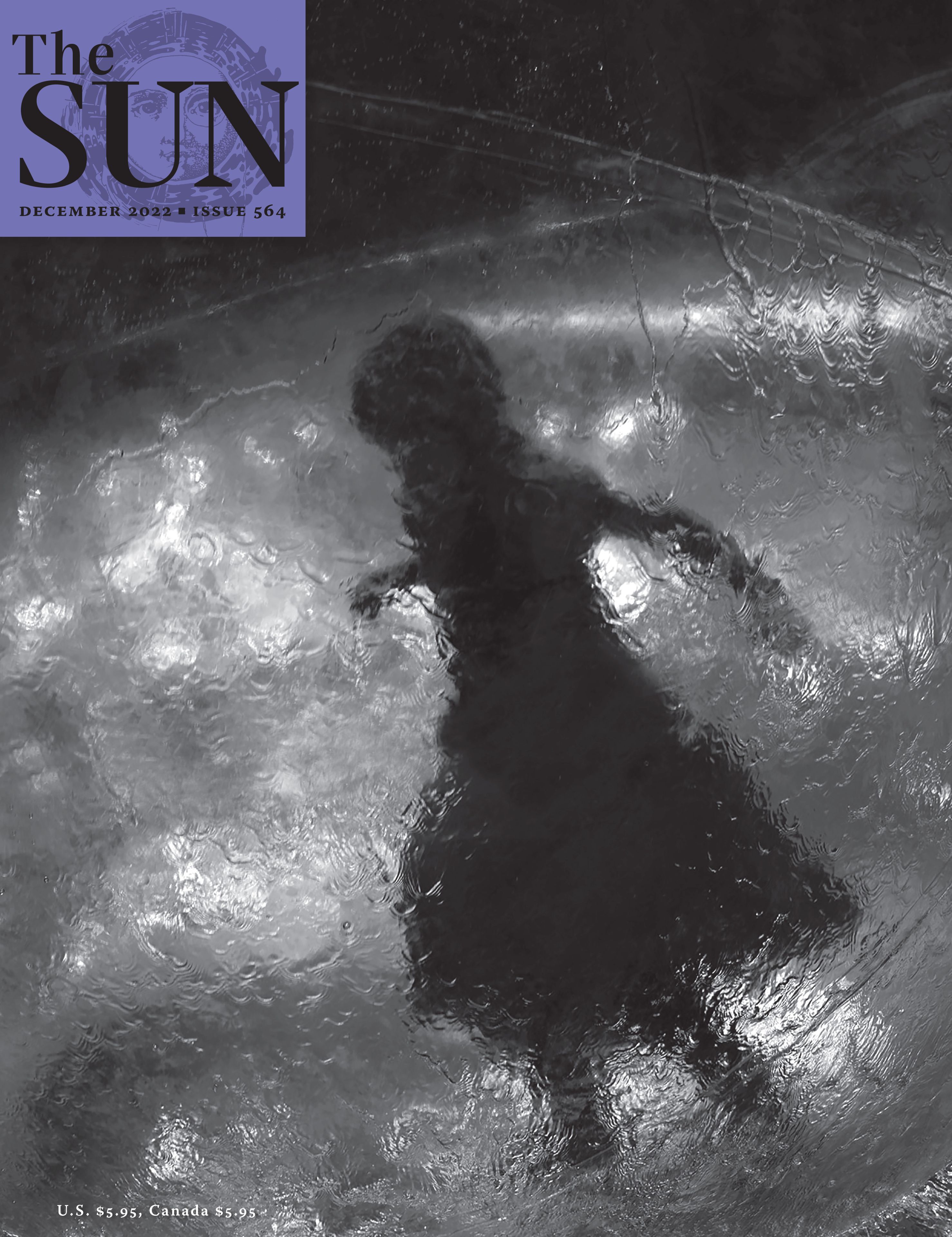 December 2022 cover of The Sun. A girl wearing a dress with her arms out to her sides stands inside of a large plastic ball. The girl is a dark figure in the plastic ball with light shining through it. The photo was taken at a carnival in Minnesota.