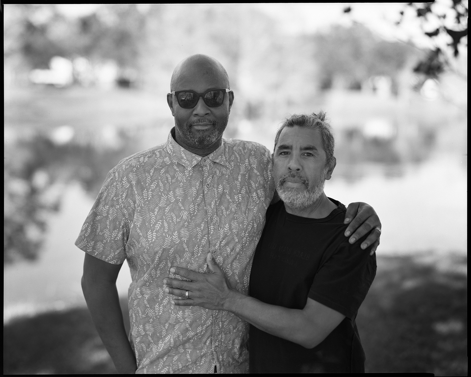 Ricardo and José stand close together outside in Winter Park, Florida, with their arms around one another as they look into the camera.