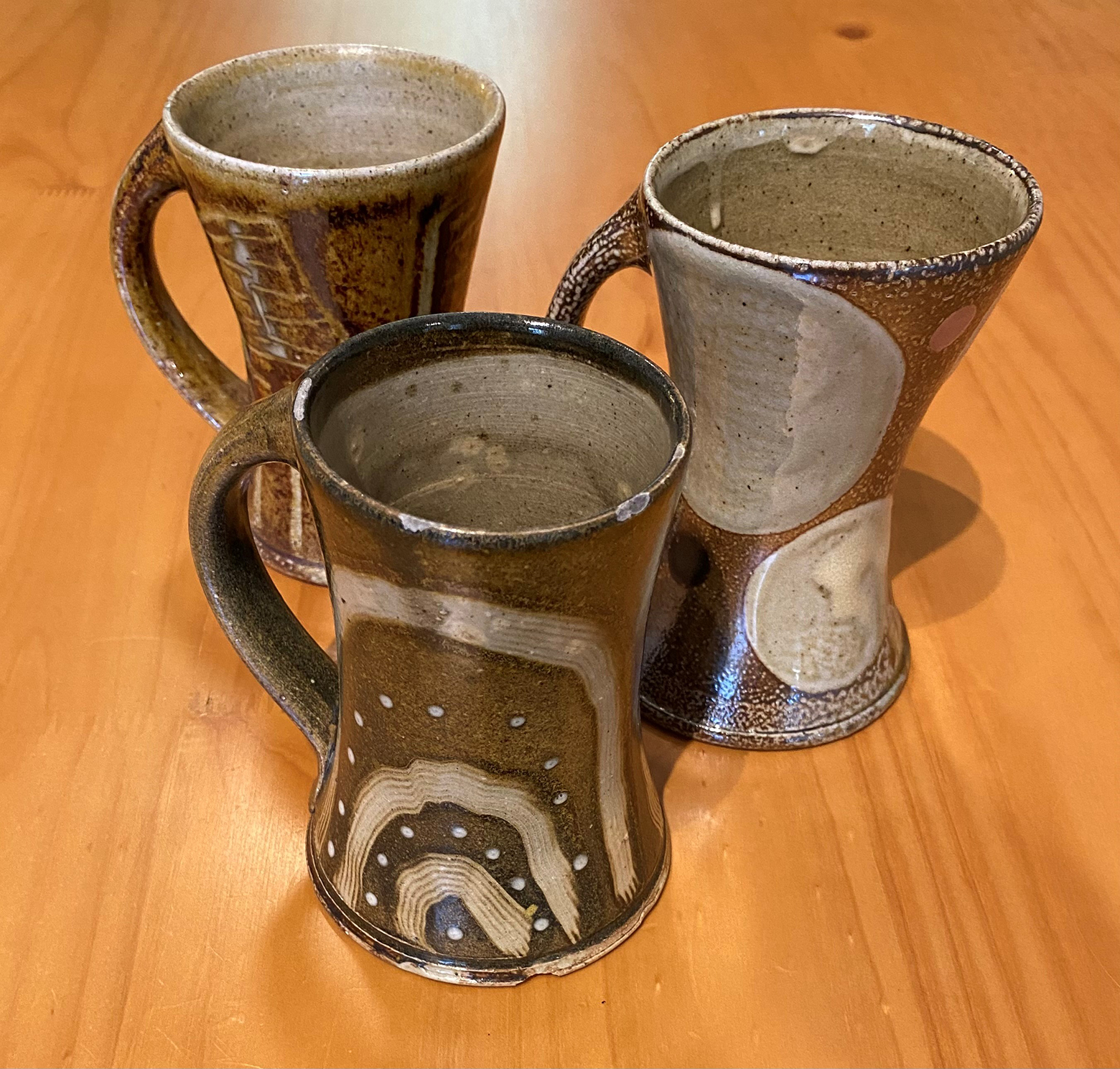 Three coffee mugs on a table.