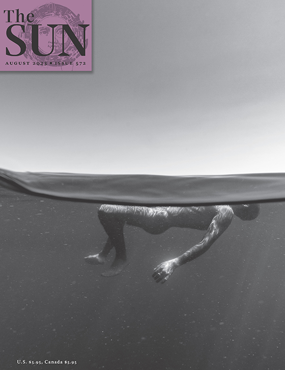 August 2023 cover of The Sun. Steven Miller took the photo on this month’s cover in 2021 as his friend Ruben floated in Lake Washington. The top half of the photo is sky and the bottom half is an underwater view of a man floating on his back.