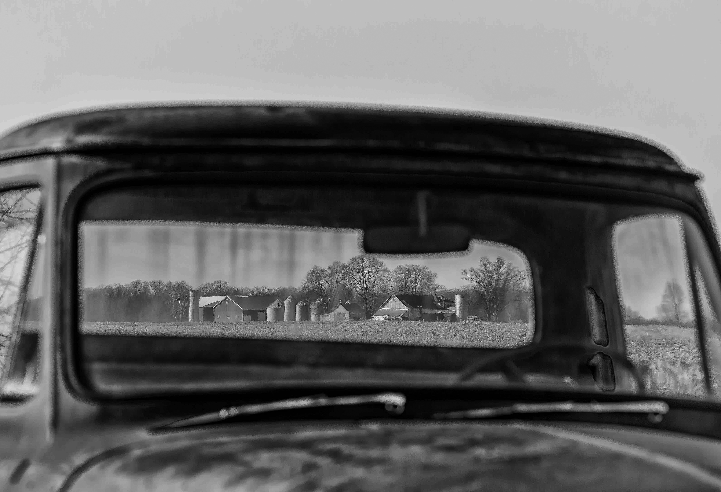 Farmstead in rural Indiana seen through the windshields of a truck: through front then back.
