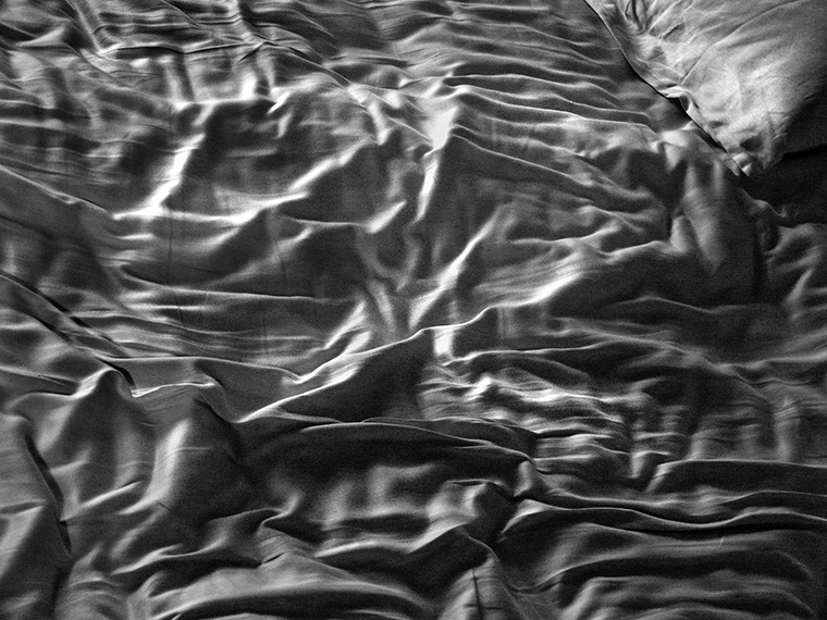 Rumpled sheets on a bed.