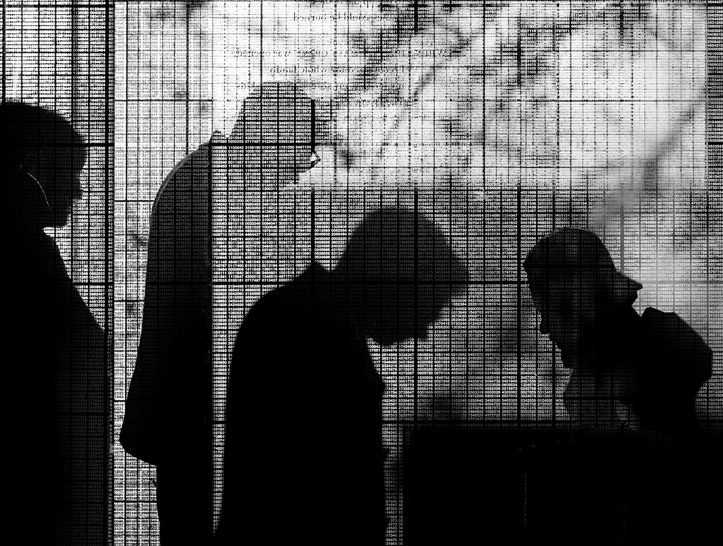 Silhouettes of four people walking through the path of the glass towers of the New England Holocaust Memorial in Boston are seemingly tattooed with the shadows of numbers etched in a grid in the glass that represent those of the Jews murdered.